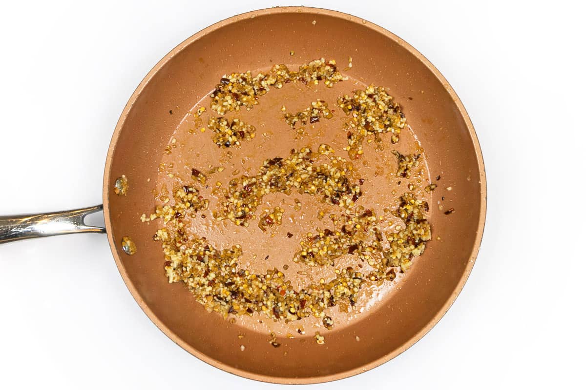 Sauté the minced ginger, chili flakes, and minced garlic for about a minute.
