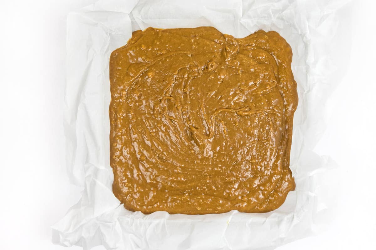 Gingerbread cake batter in a pan with parchment paper.