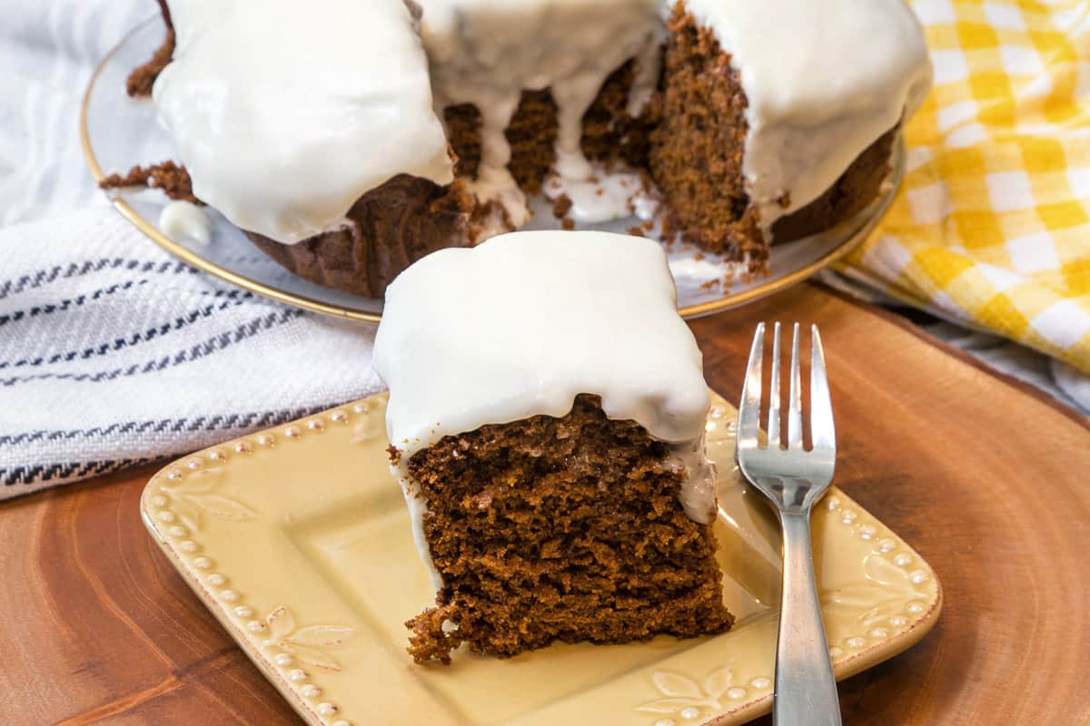 Gingerbread cake with cream cheese frosting on a plate.