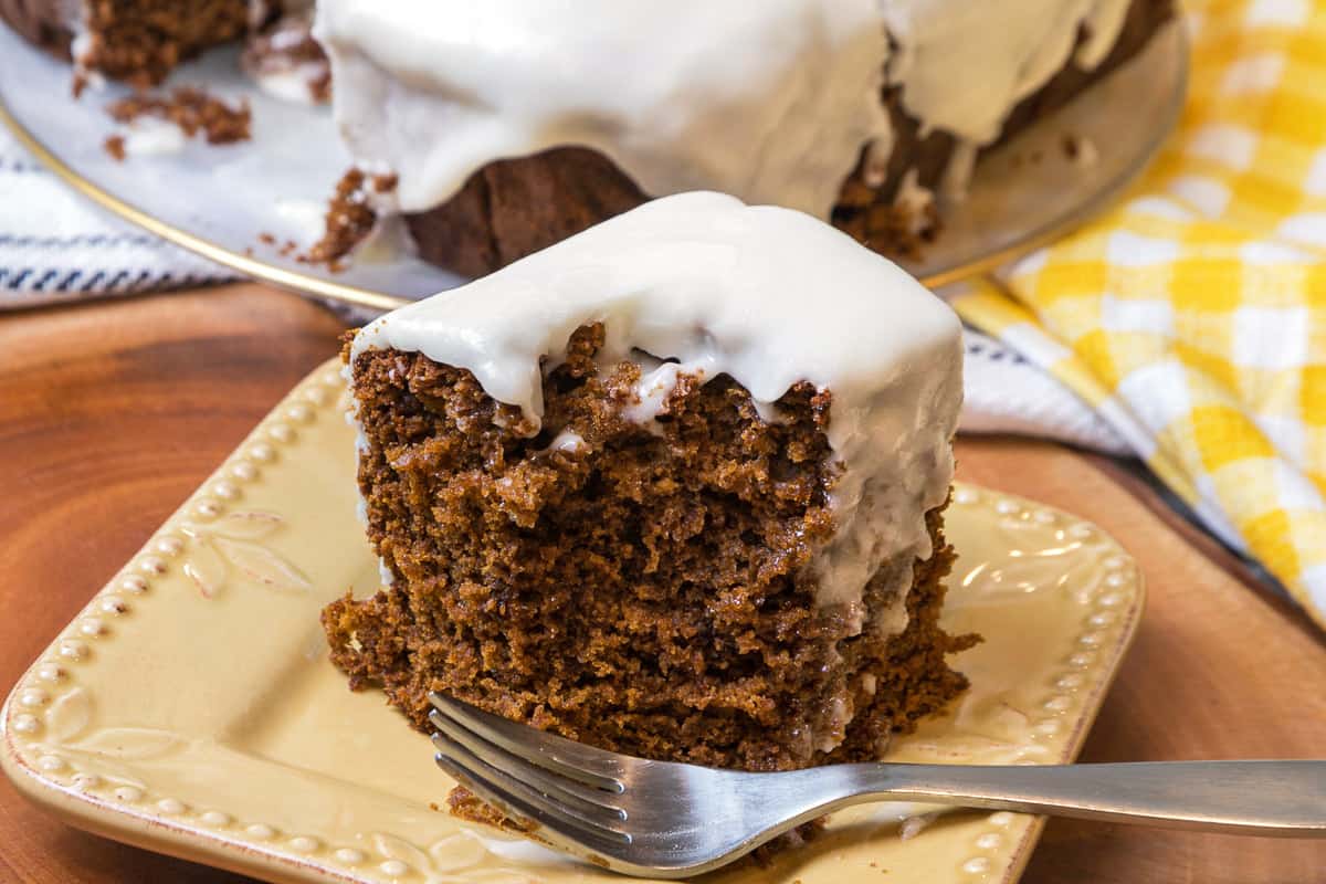 Gingerbread cake with cream cheese frosting on a plate.