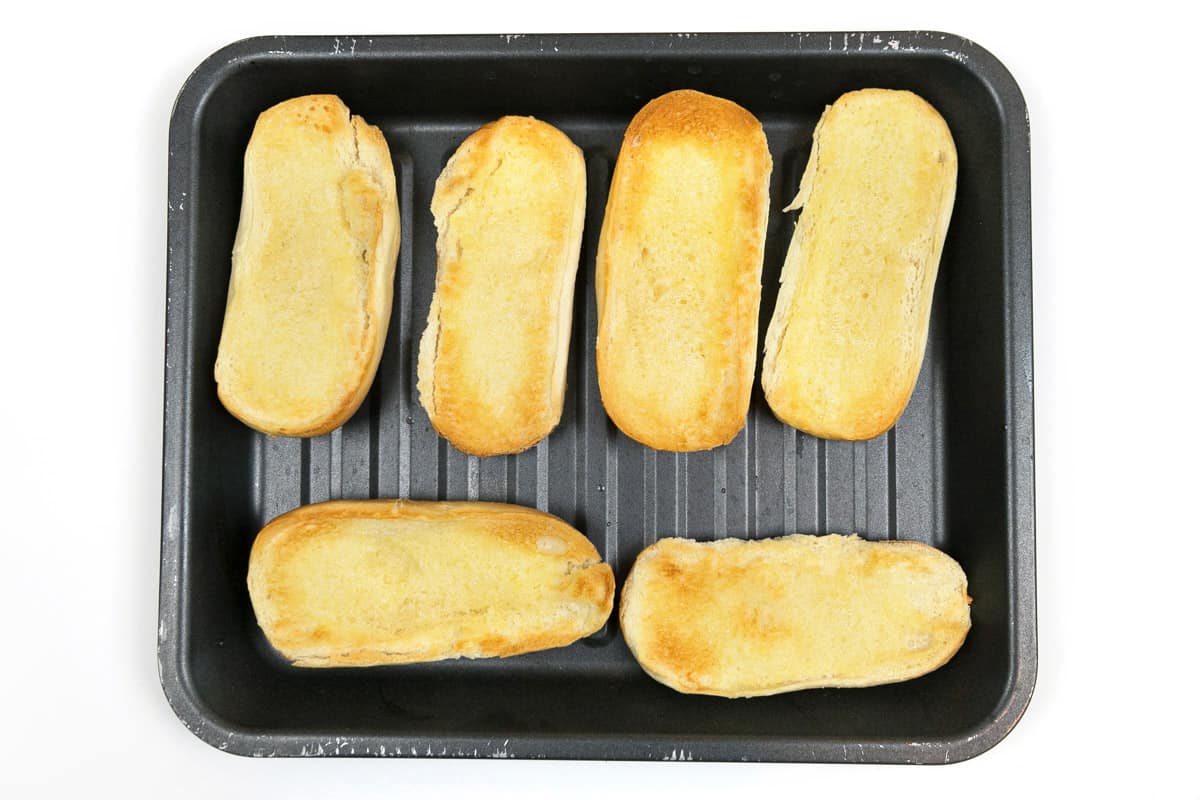 Buttered hoagie rolls grilled under the broiler.