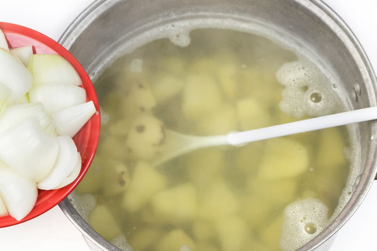 Add the onions to the water with the potatoes.