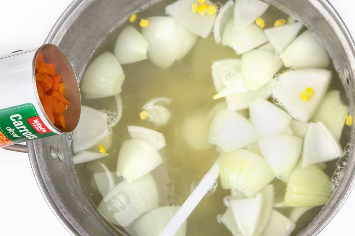 Drain the liquid out of the cans of carrots and add them to the pot of soup.