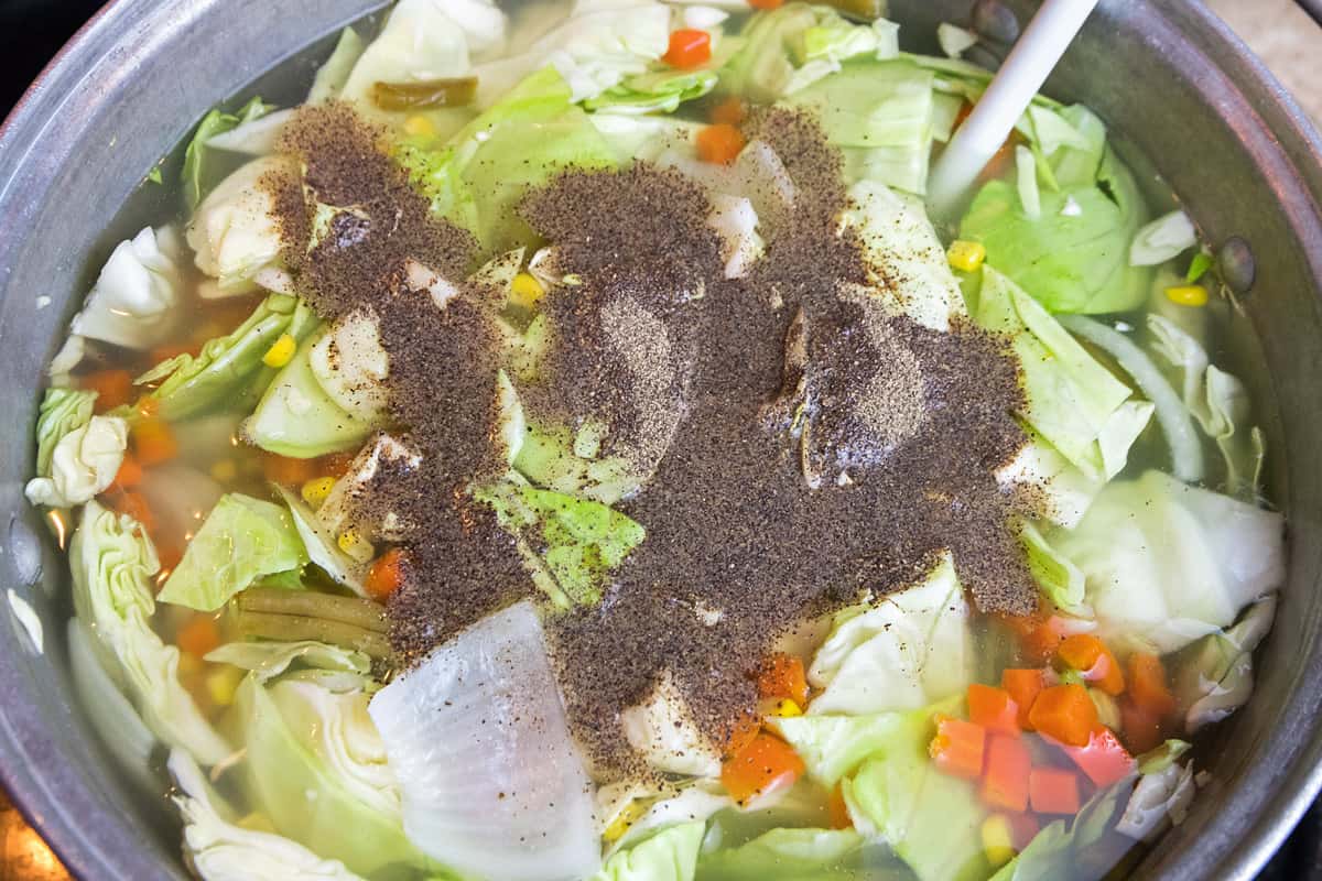 Add the rest of the vegetables and black pepper to the pot of soup.