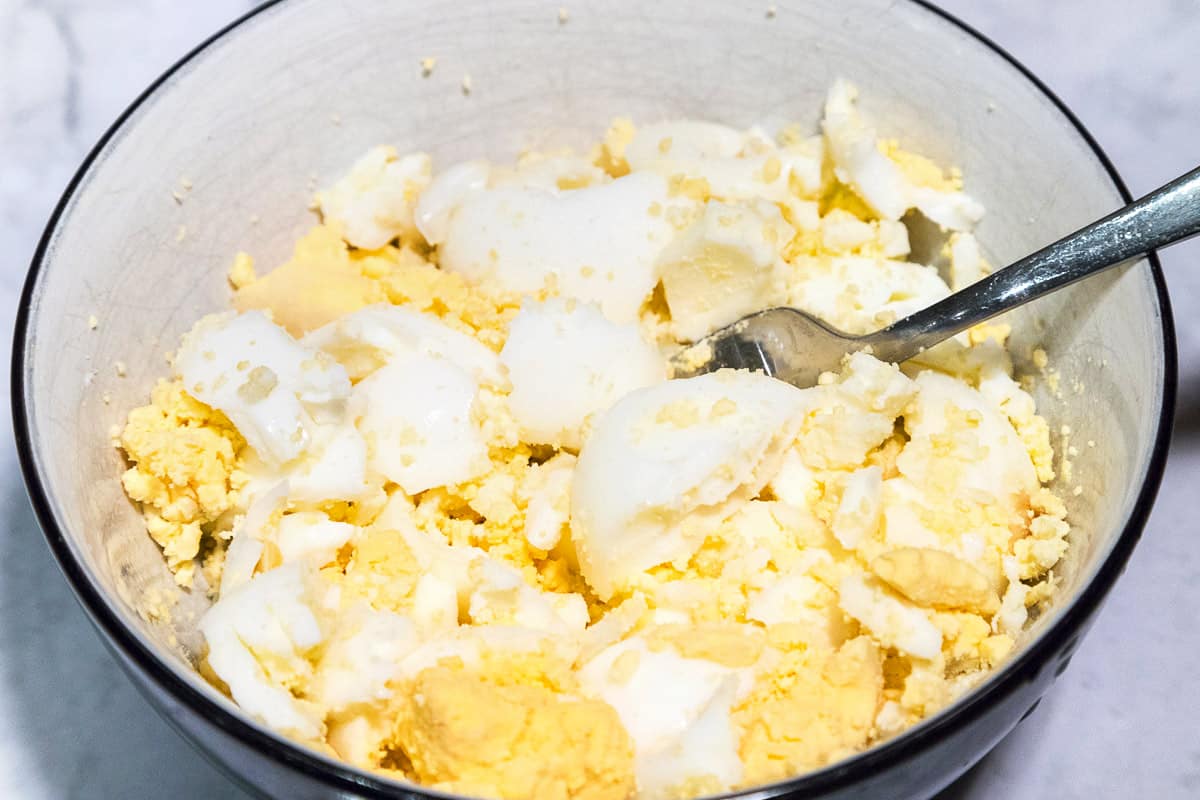 Hard-boiled eggs mixed in a bowl.