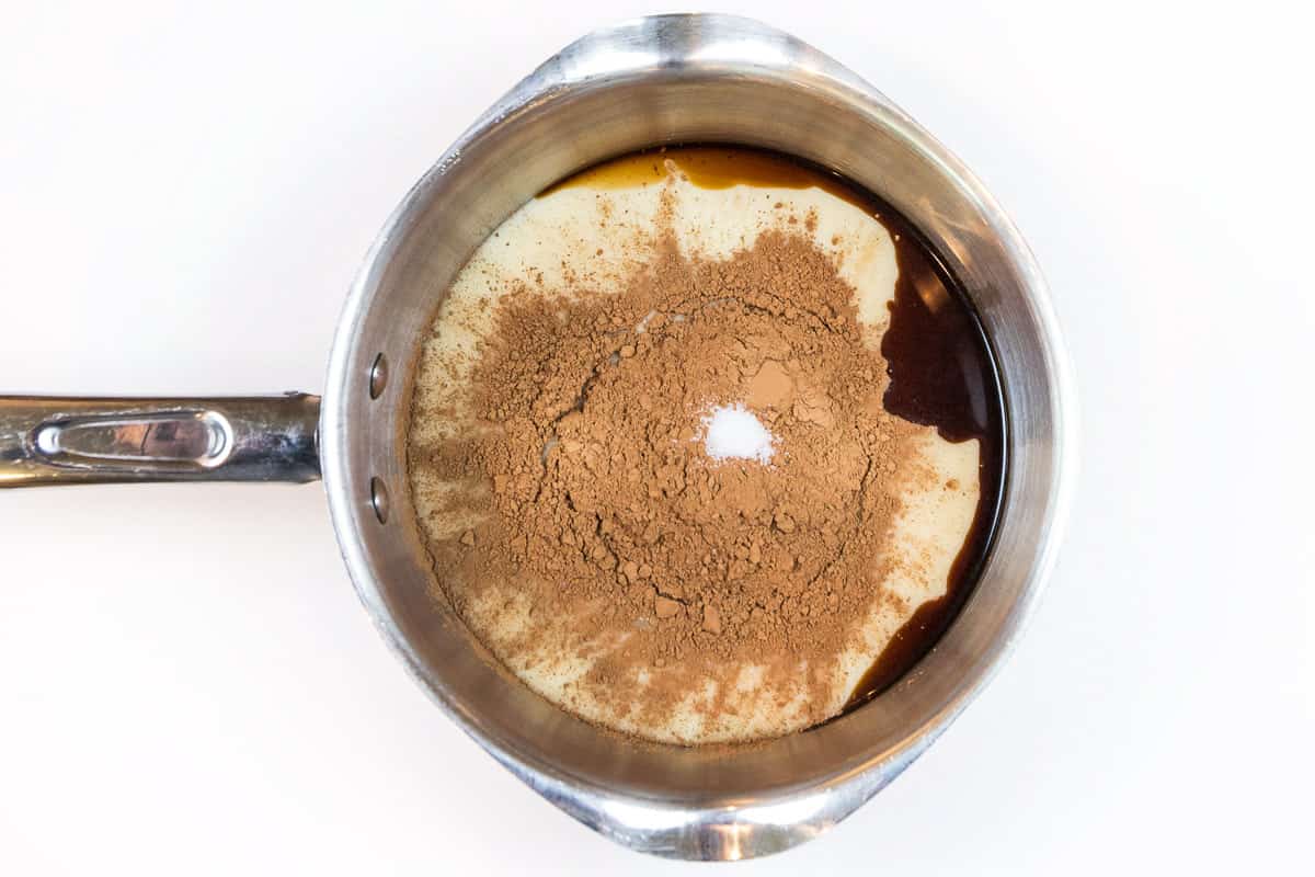 Sweetened condensed milk, unsweetened cocoa powder, vanilla extract, and salt in a pot.