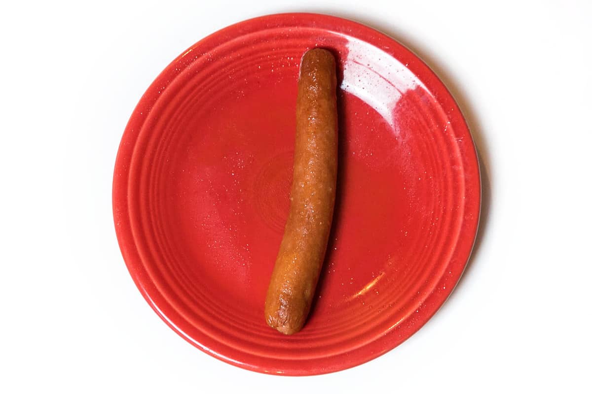 A cooked hot dog on a plate.