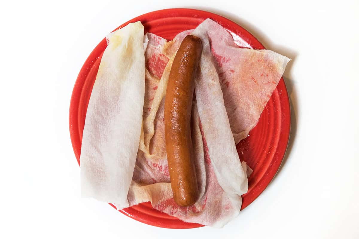 A frozen hot dog in a damp paper towel.