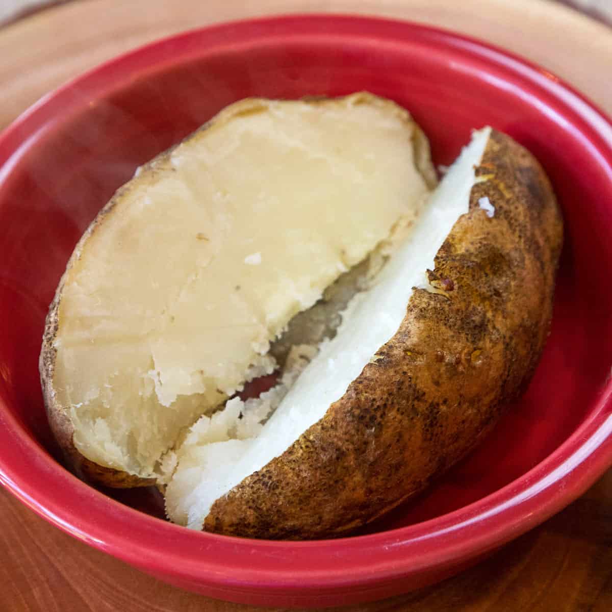 Baked potato in a bowl after being cooked in the oven without foil.