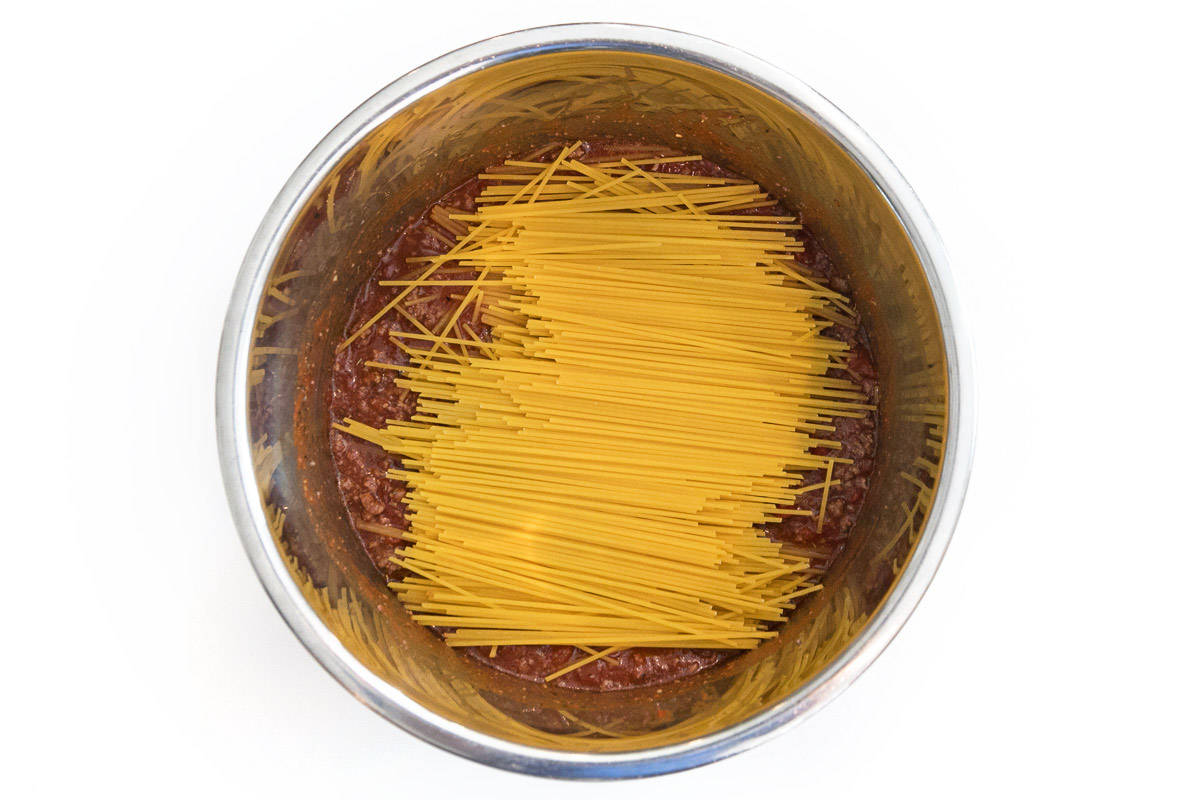 Lay the spaghetti noodles over the meat sauce.