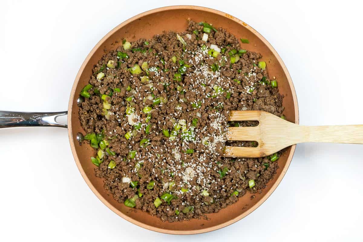 Add the sesame seeds to the frying pan with the ground beef mixture and simmer for one to two more minutes.