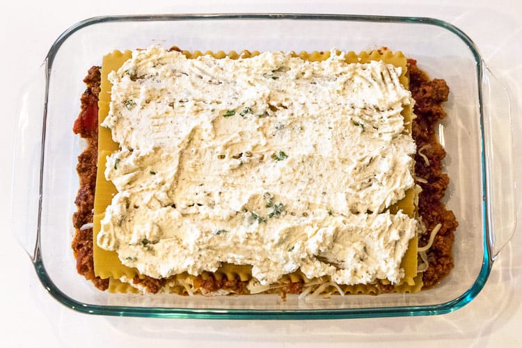 Another layer of the ricotta cheese mixture is put in the baking dish.