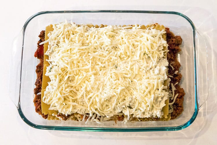 Another layer of mozzarella cheese is put in the baking dish.