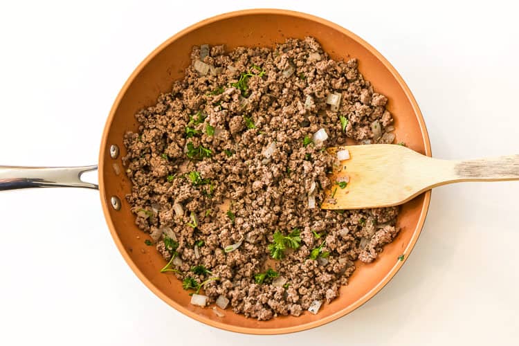 The lean ground beef mixture frying on the stove on medium heat.