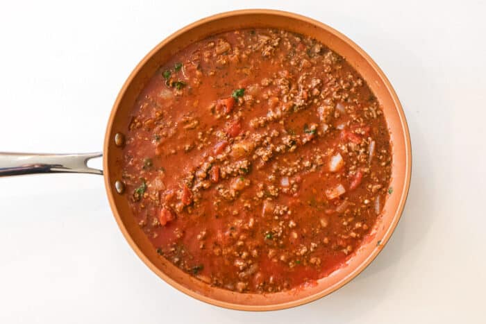 Tomato sauce added to ground beef mixture.