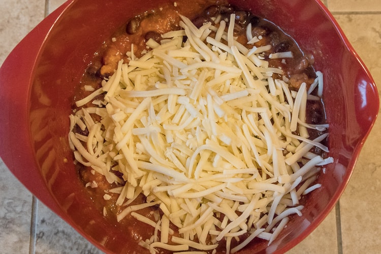 Monterey Jack cheese, sharp cheddar cheese, salsa, refried beans, and black bean in a bowl.