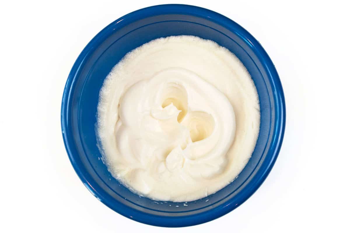 The egg whites and vanilla extract are whipped in a bowl.