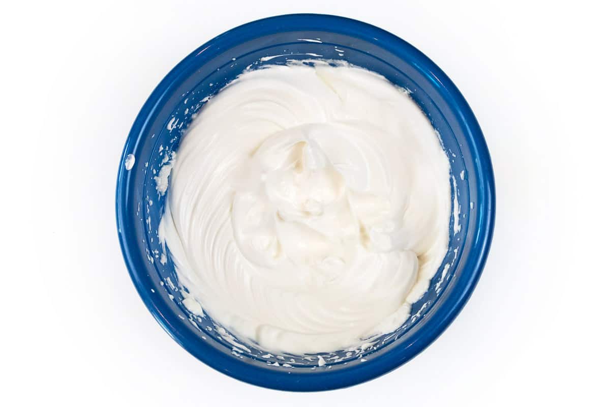 Gradually add the sugar to the three whipped egg whites and one teaspoon of vanilla extract.