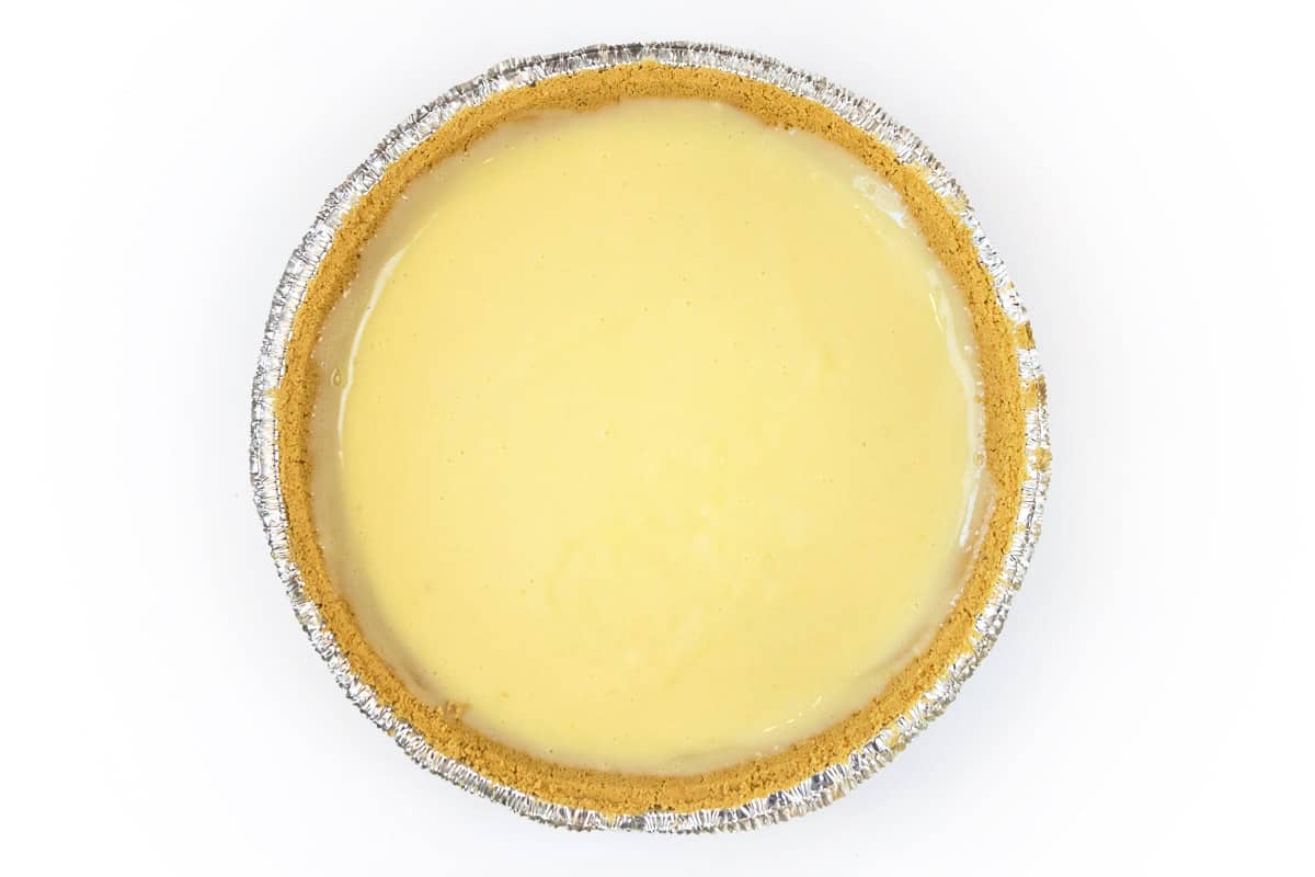Pour the lemon filling into the pie crust.