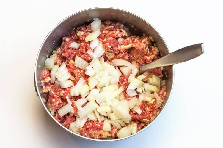Diced onions added to the ground beef mixture.