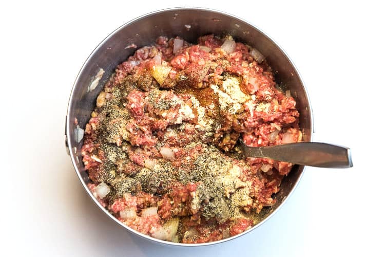The seasonings are added to the ground beef mixture.