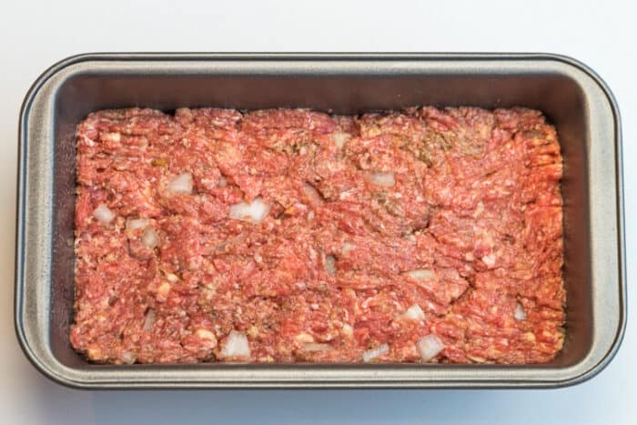 Unbaked meatloaf in a loaf pan.
