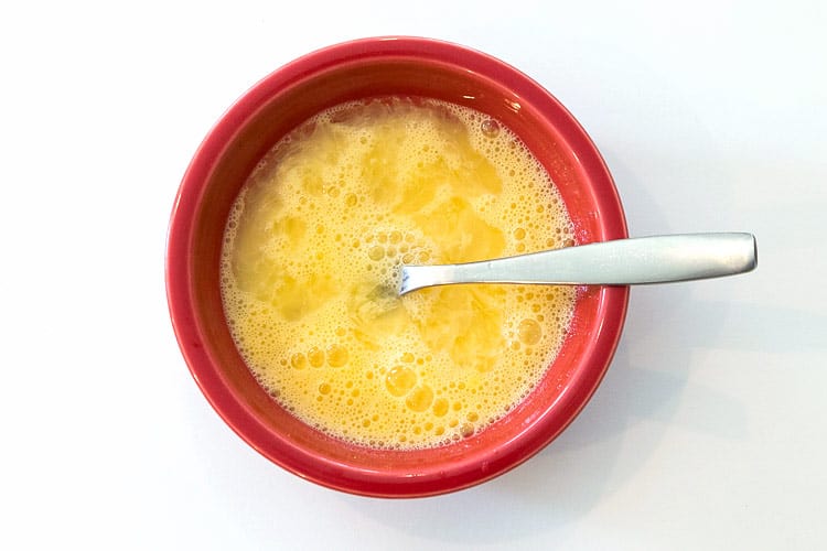 Beaten eggs and cold water in a bowl.