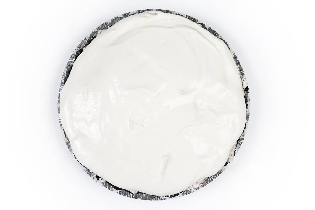 Homemade whipped cream is spread across the top of the Oreo cheesecake.