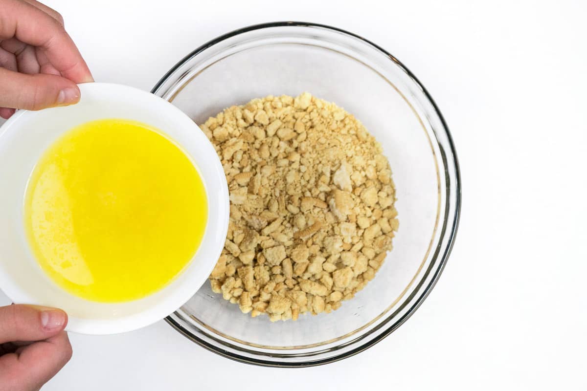 Add the melted butter to the crushed Oreo golden cookies.