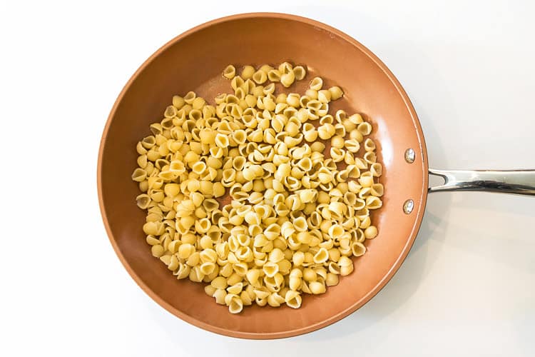 Cooked pasta noodles were added to the butter in the frying fan.