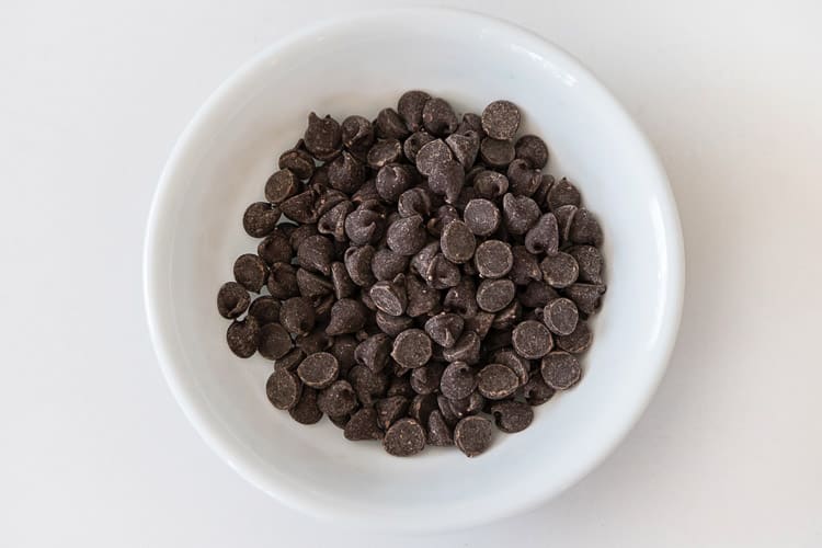 One half cup of chocolate chips in a microwaveable bowl.