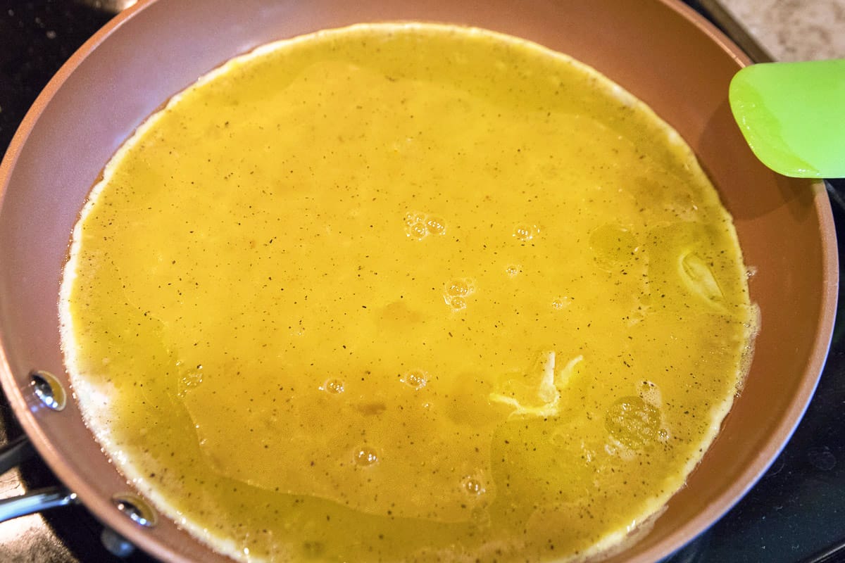 Put the beaten eggs into the frying pan with the olive oil.