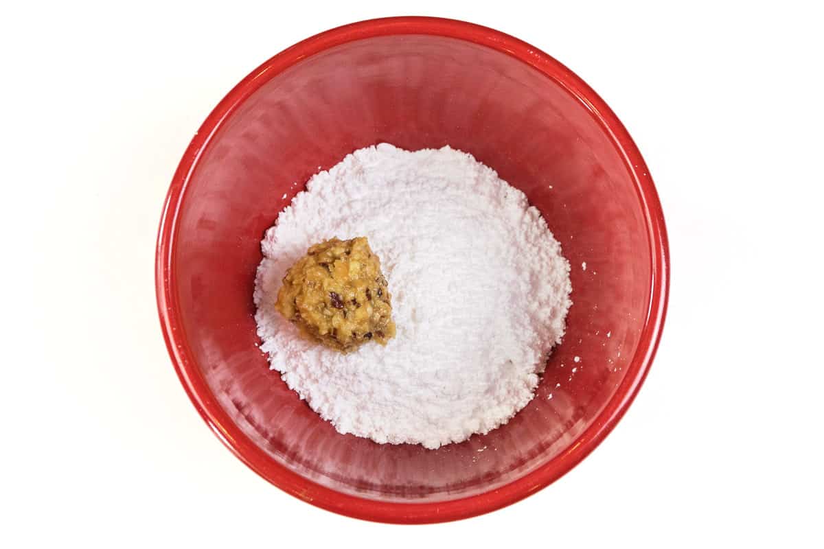 Put an orange ball into the powdered sugar.