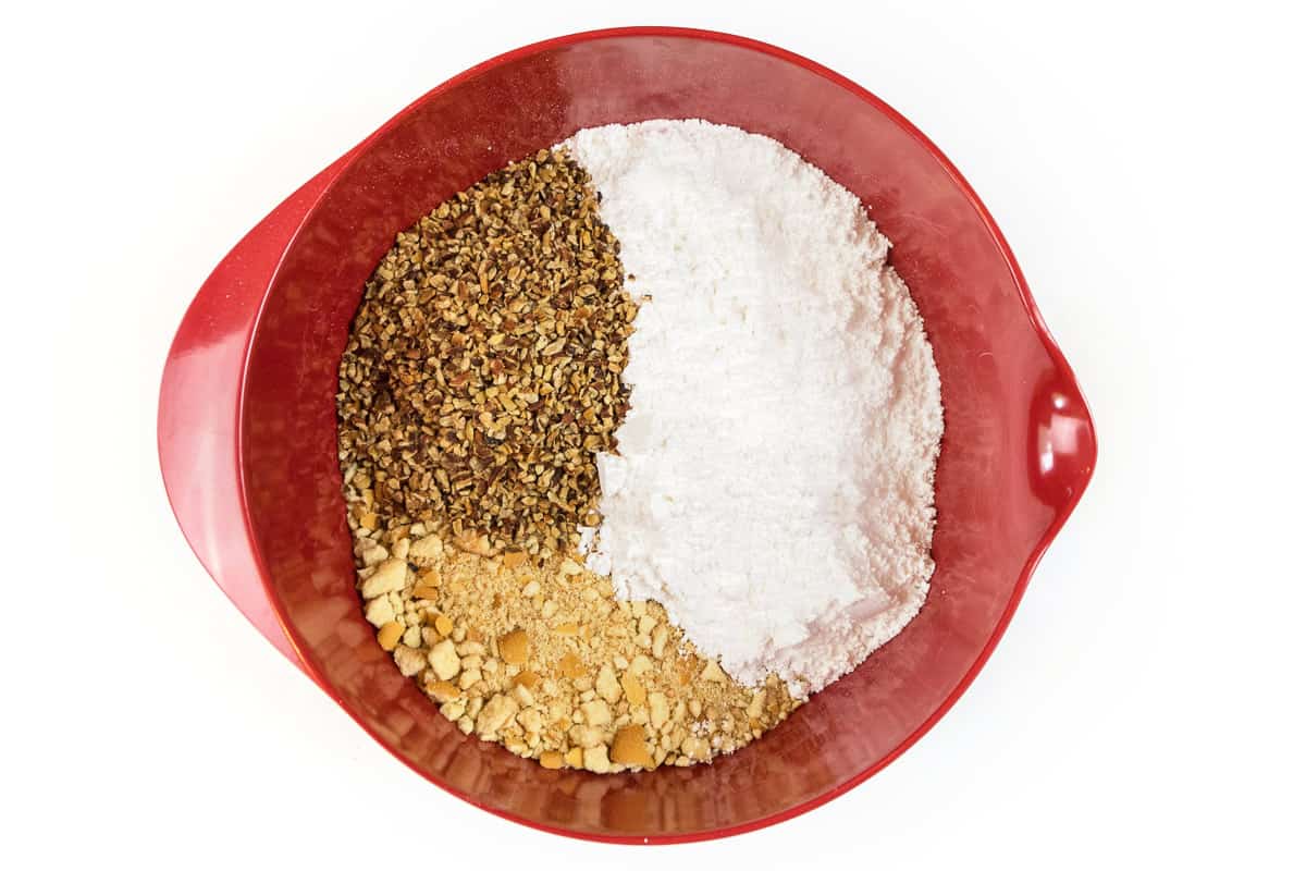 Put the pecans, powdered sugar, and vanilla wafers in a bowl.