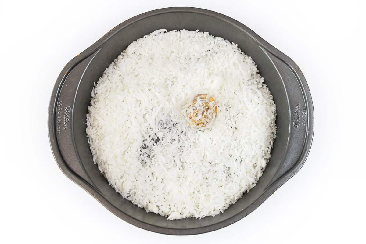 Roll the orange ball into the coconut.