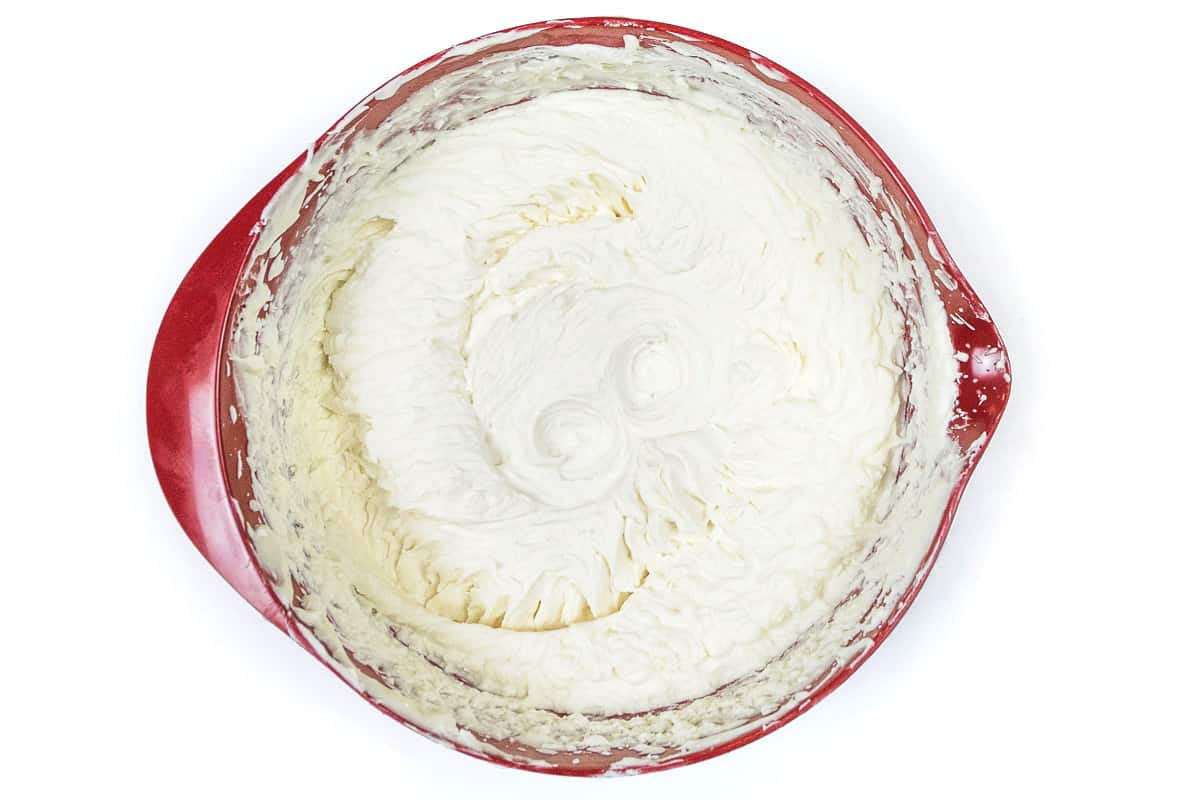 Sweetened condensed milk and heavy whipped cream are mixed thoroughly.