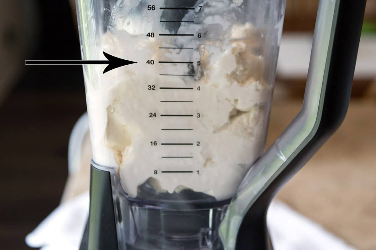 Add five cups of vanilla bean ice cream to the five-cup line on the blender and then add one and a half cups of two percent milk.