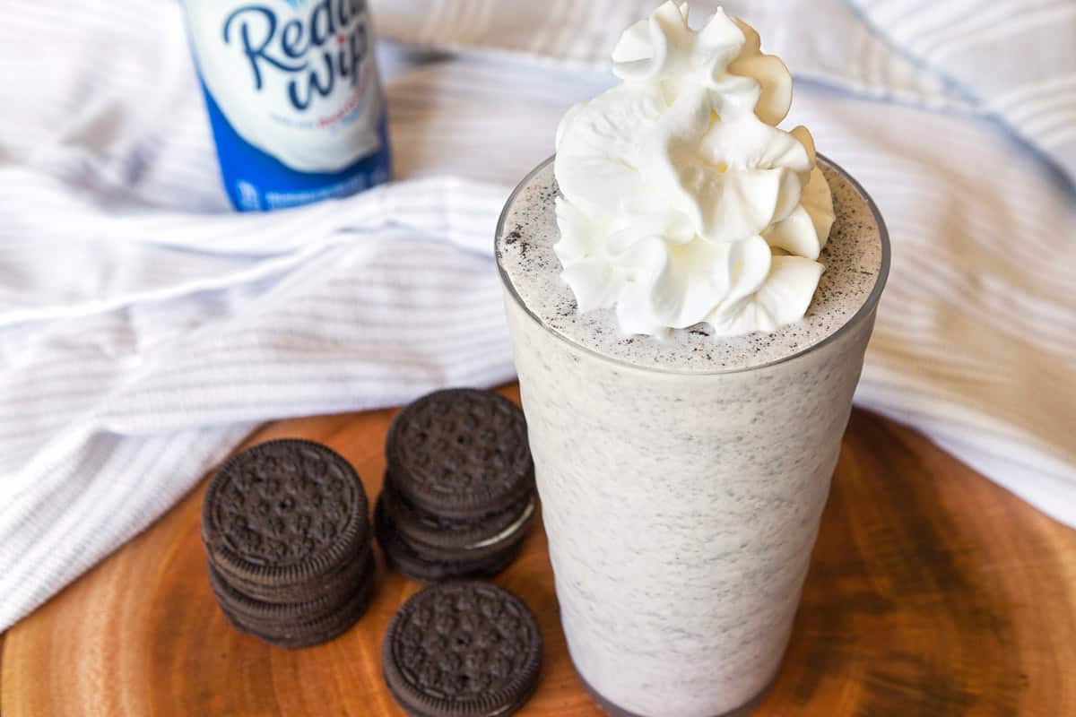 Oreo Milkshake Recipe with Vanilla Extract in a cup with whipped cream on top.