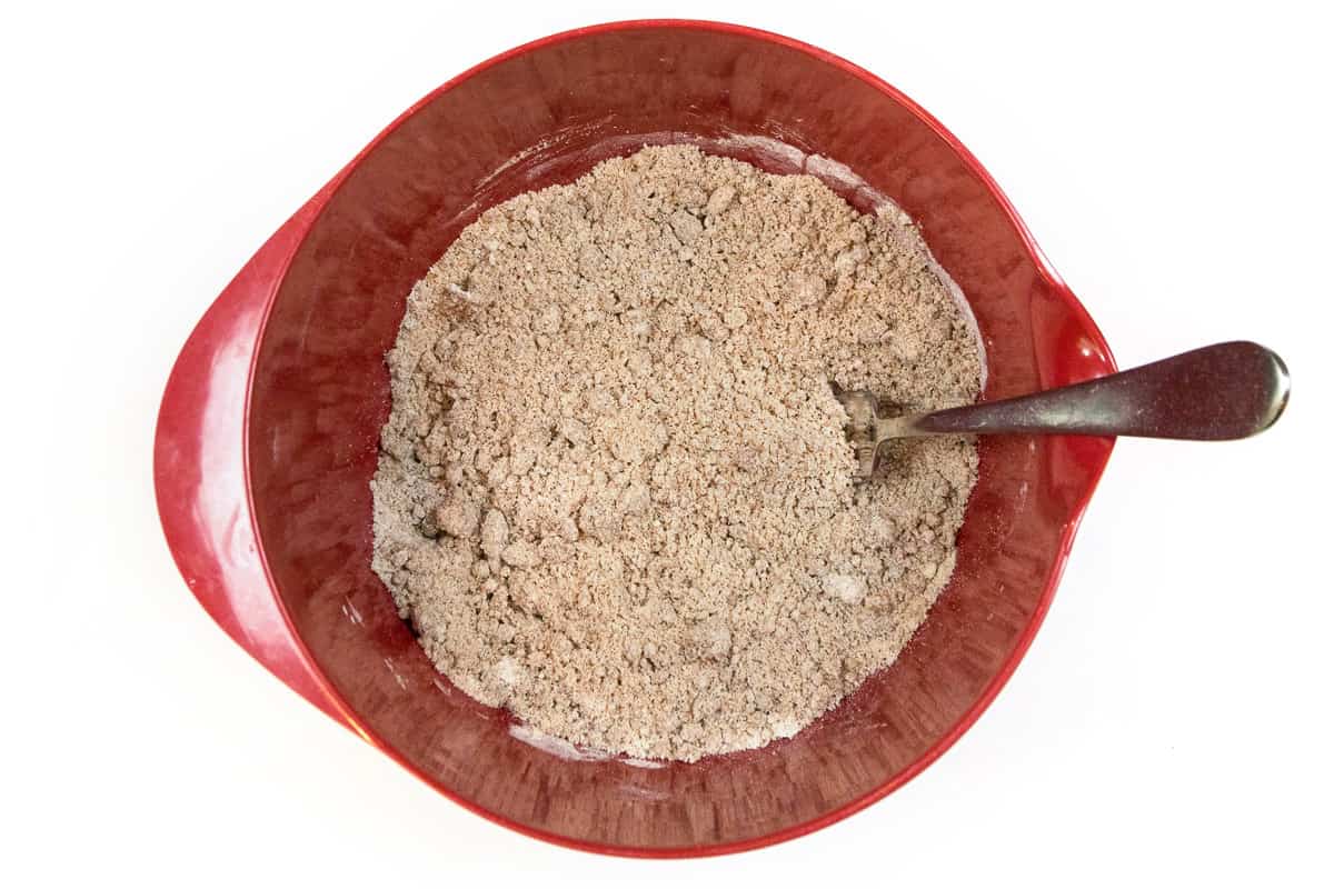 Slowly add the flour to the melted butter, sugar, brown sugar, and cinnamon.