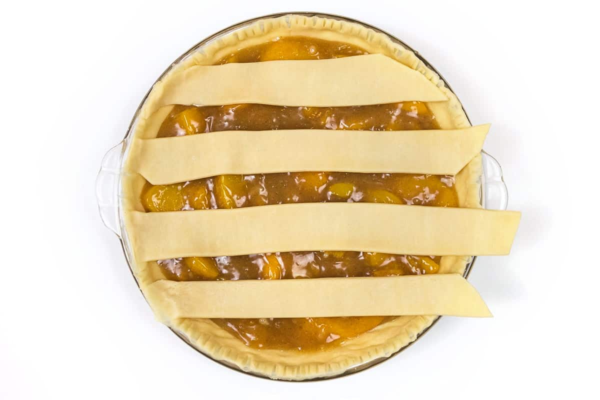 Put 4 strips of pie dough over the pie filling.
