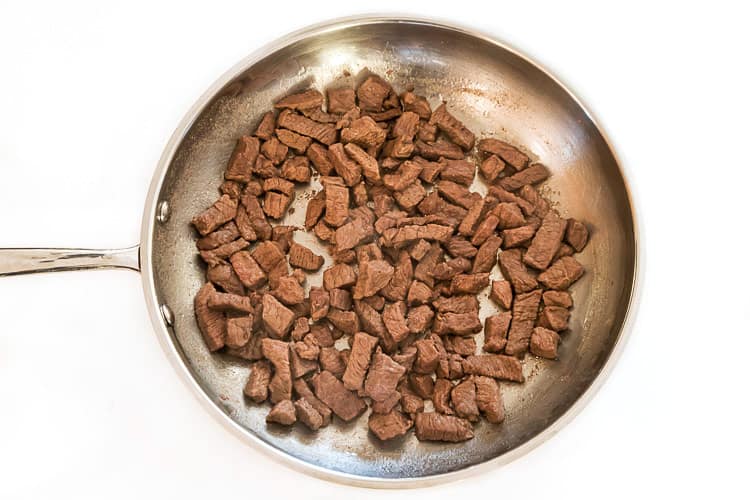 Steak browned in a frying pan.