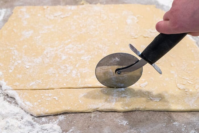 Cutting the pierogies dough into squares.