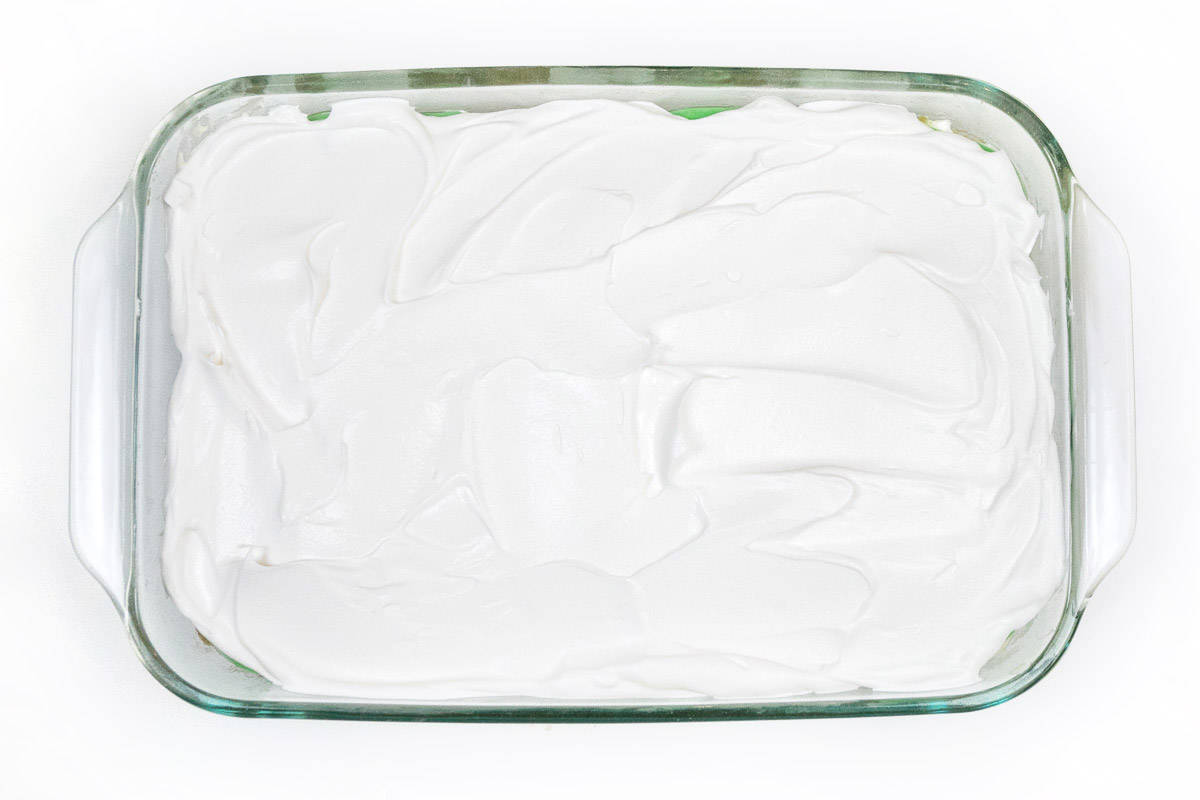 The other half of the whipped topping is spread on top of the pistachio pudding layer.