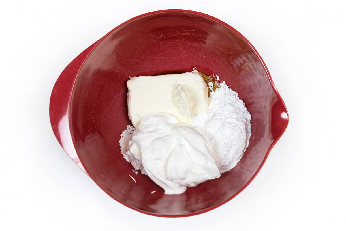 Cream cheese, vanilla extract, powdered sugar, and half of the tub of whipped topping in a mixing bowl.