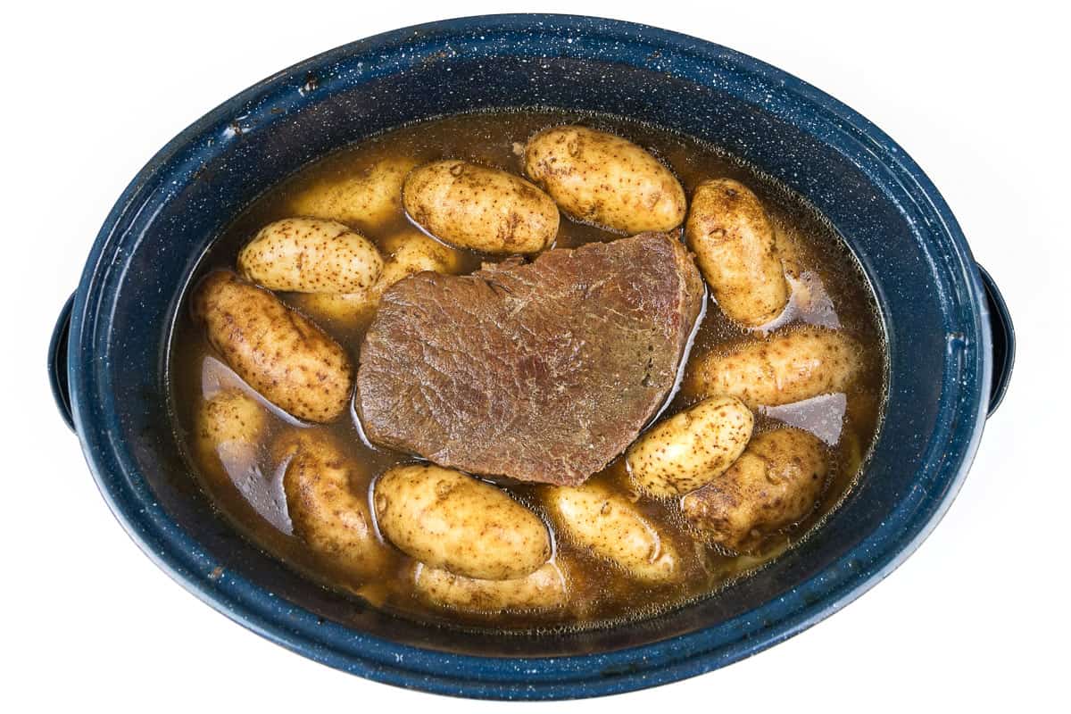 Pot roast with cut up onions and potatoes.