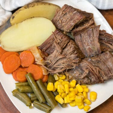 Pot roast cooked in the oven all done on a whute plate.