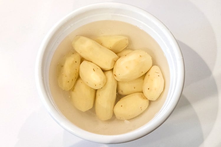 Peeled potatoes in water.