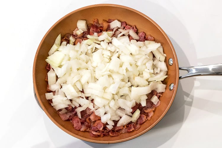 Onions added to bacon in frying pan.