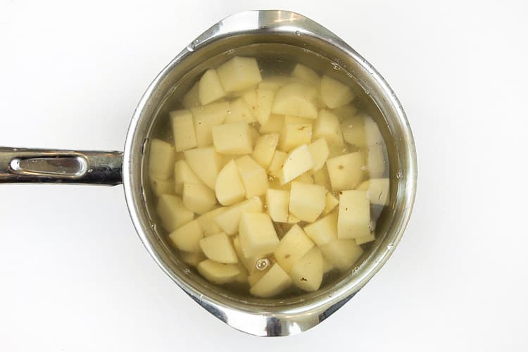Peel the potatoes, cut into cubes, and boil them.
