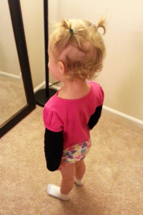 Toddler looking in the mirror.